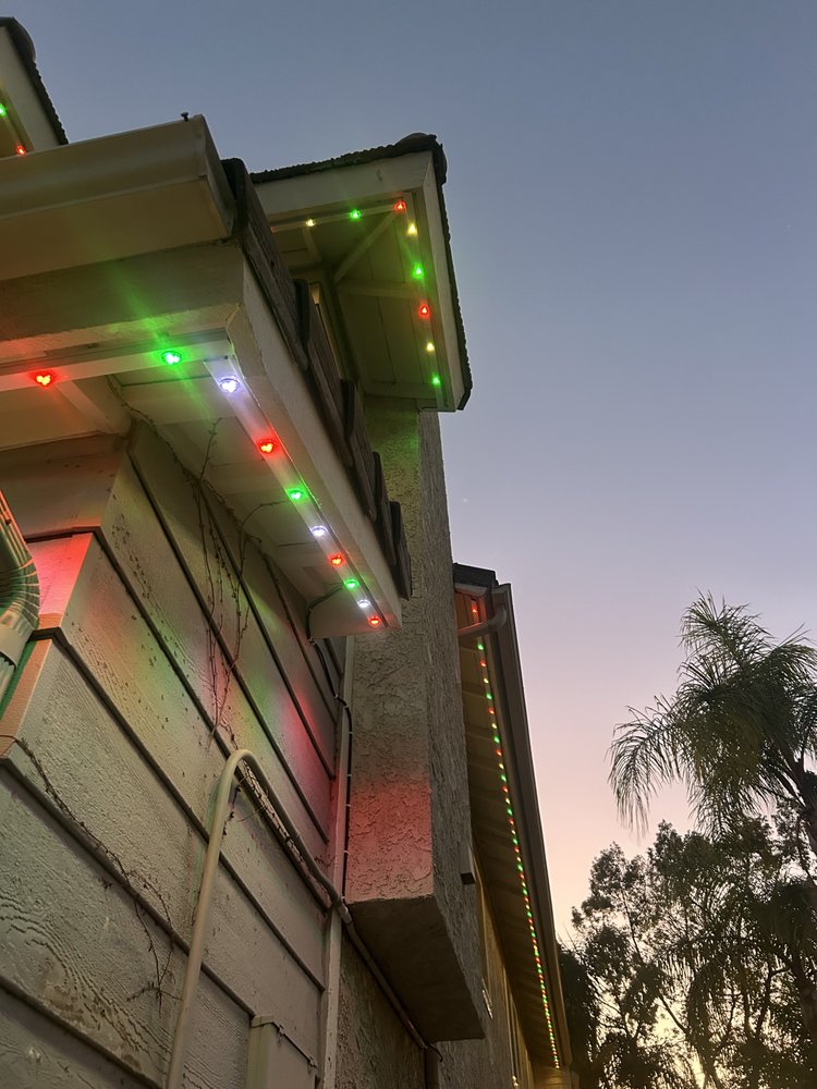 Eave and fascia lit in red, white and green Christmas colors at dusk